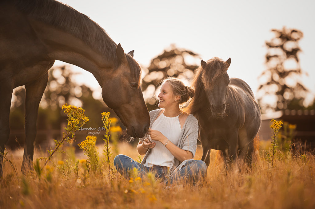 Een meisje dat geniet van een paardenfotoshoot met twee paarden